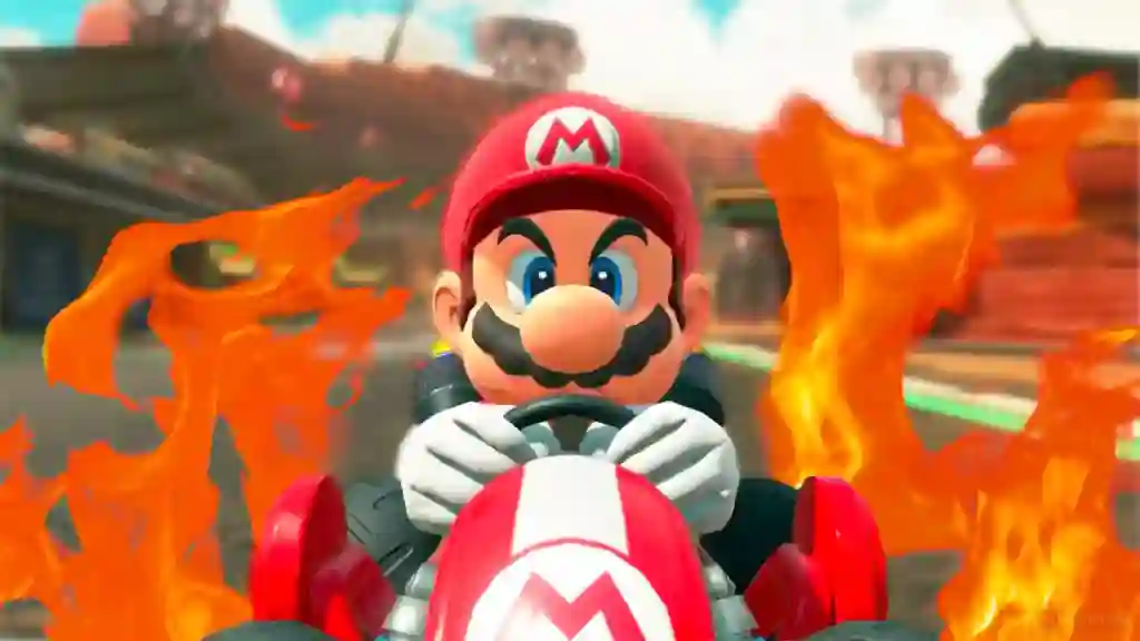 Mario conduce su kart rojo en Mario Kart World rodeado de llamas tras la polémica actualización del juego.