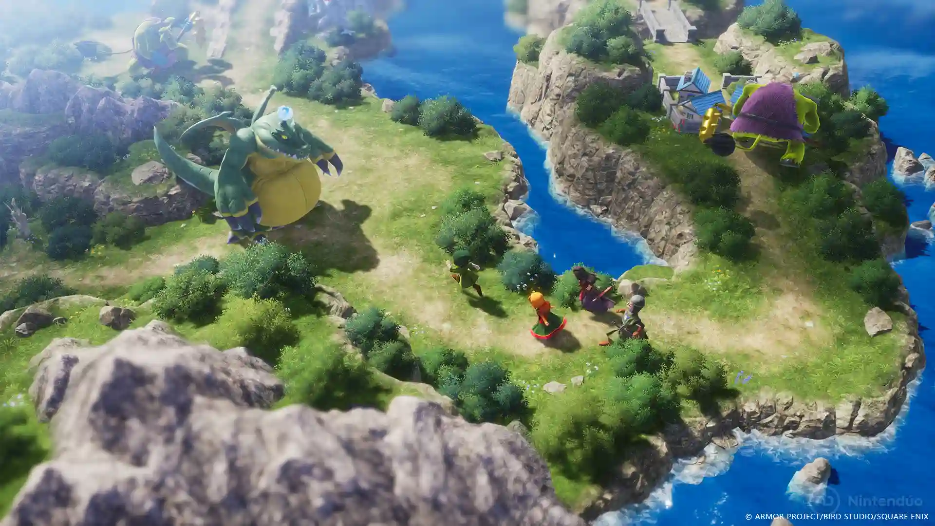 Dragon Quest VII Reimagined: vista aérea de una isla con acantilados y ríos azules donde un enorme monstruo verde y un grupo de aventureros caminan, mientras un monstruo violeta flota cerca.