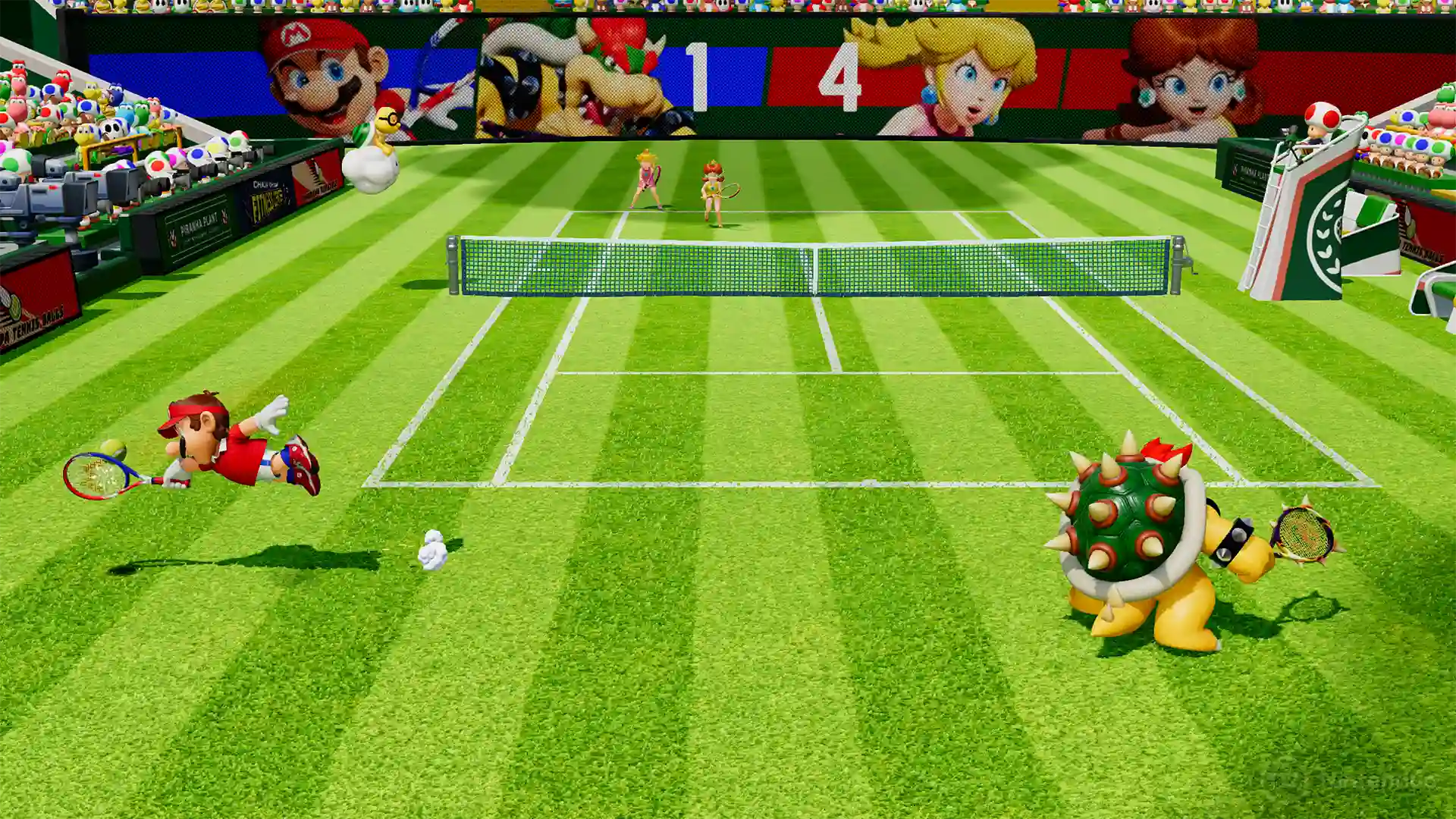 Mario Tennis Fever – partido en una cancha de hierba donde Mario se lanza en el aire para devolver la pelota con su raqueta y Bowser espera al otro lado, con un marcador gigante y retratos de los personajes adornando el estadio.