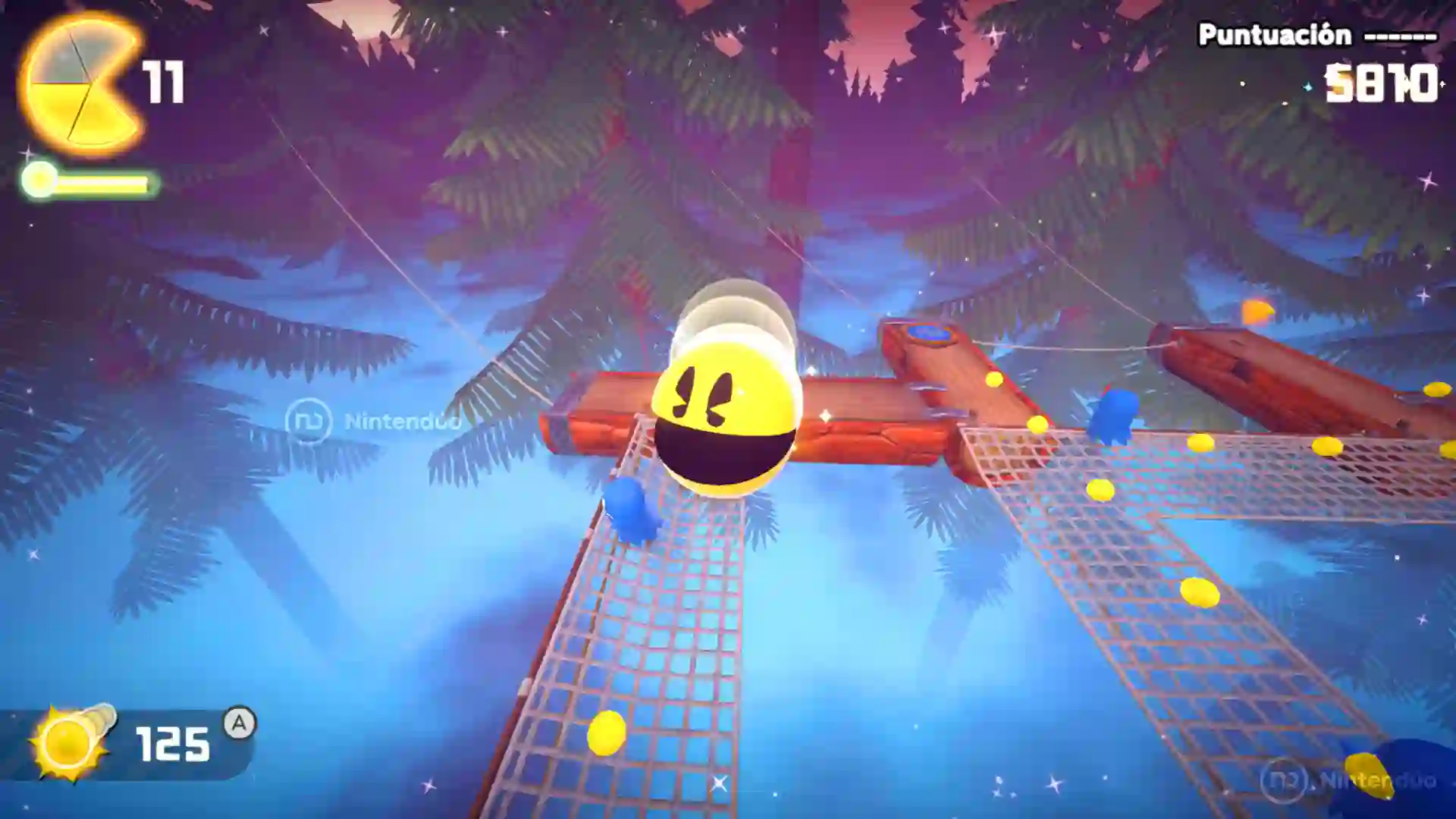 Captura de Pac‑Man World 2 Re‑Pac con Pac‑Man rodando dentro de una burbuja transparente sobre puentes de red en un nivel nocturno, recogiendo esferas amarillas.