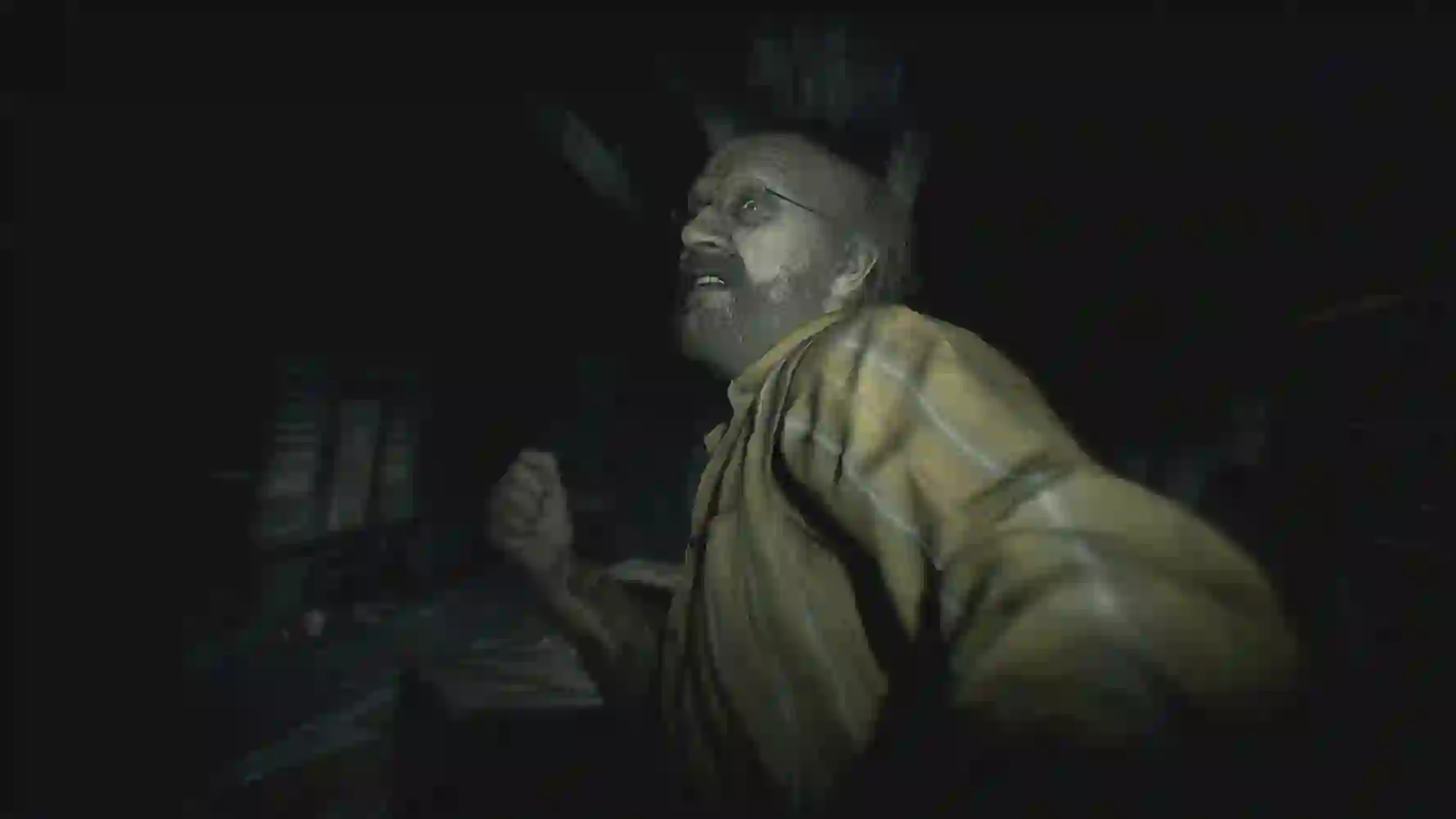 Resident Evil 7: escena oscura en primera persona con un hombre mayor con barba y camisa a rayas acercándose y alzando el puño.