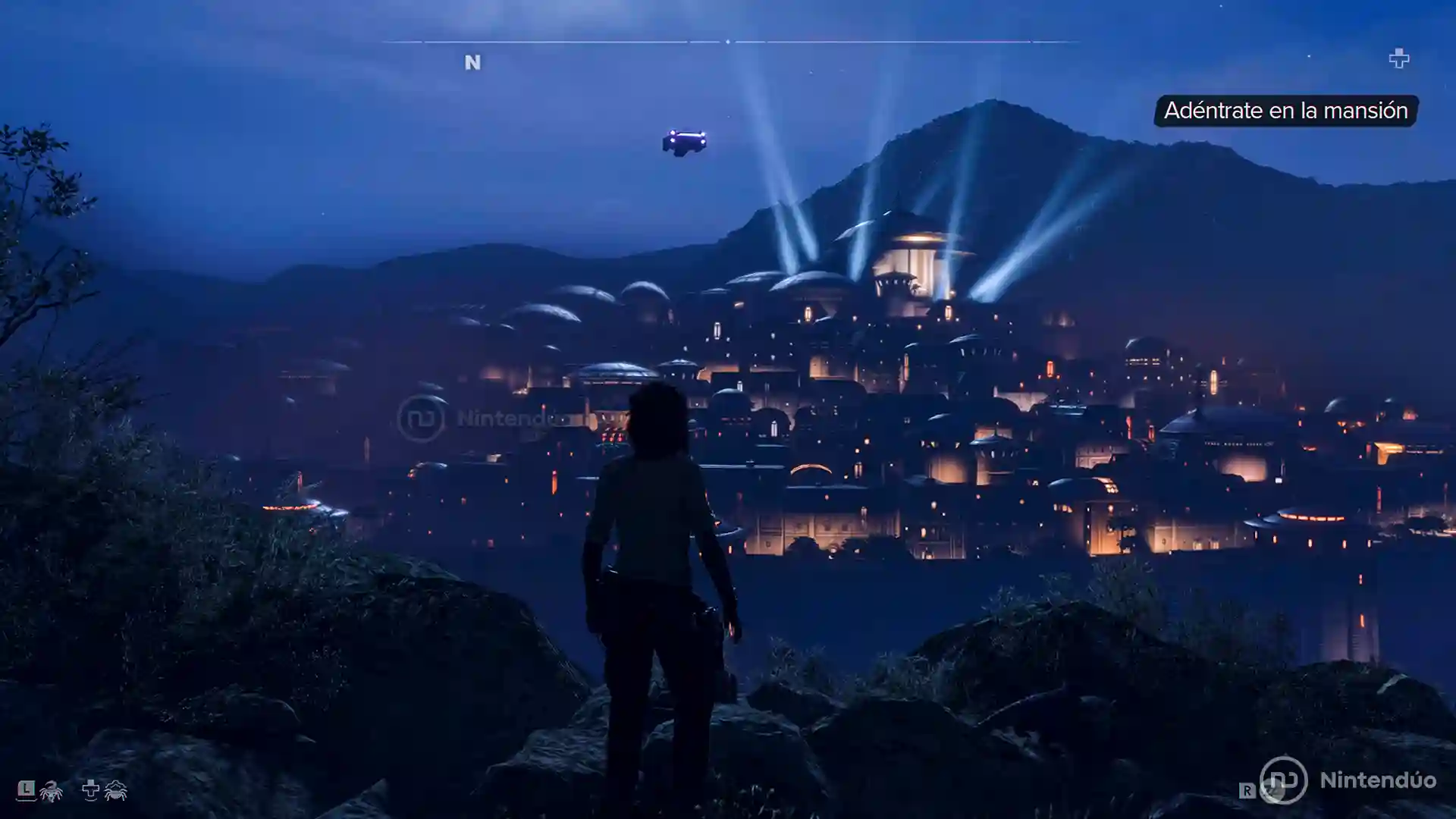 Kay Vess observa una ciudad iluminada con reflectores en la noche en Star Wars Outlaws mientras se prepara para adentrarse en la mansón.