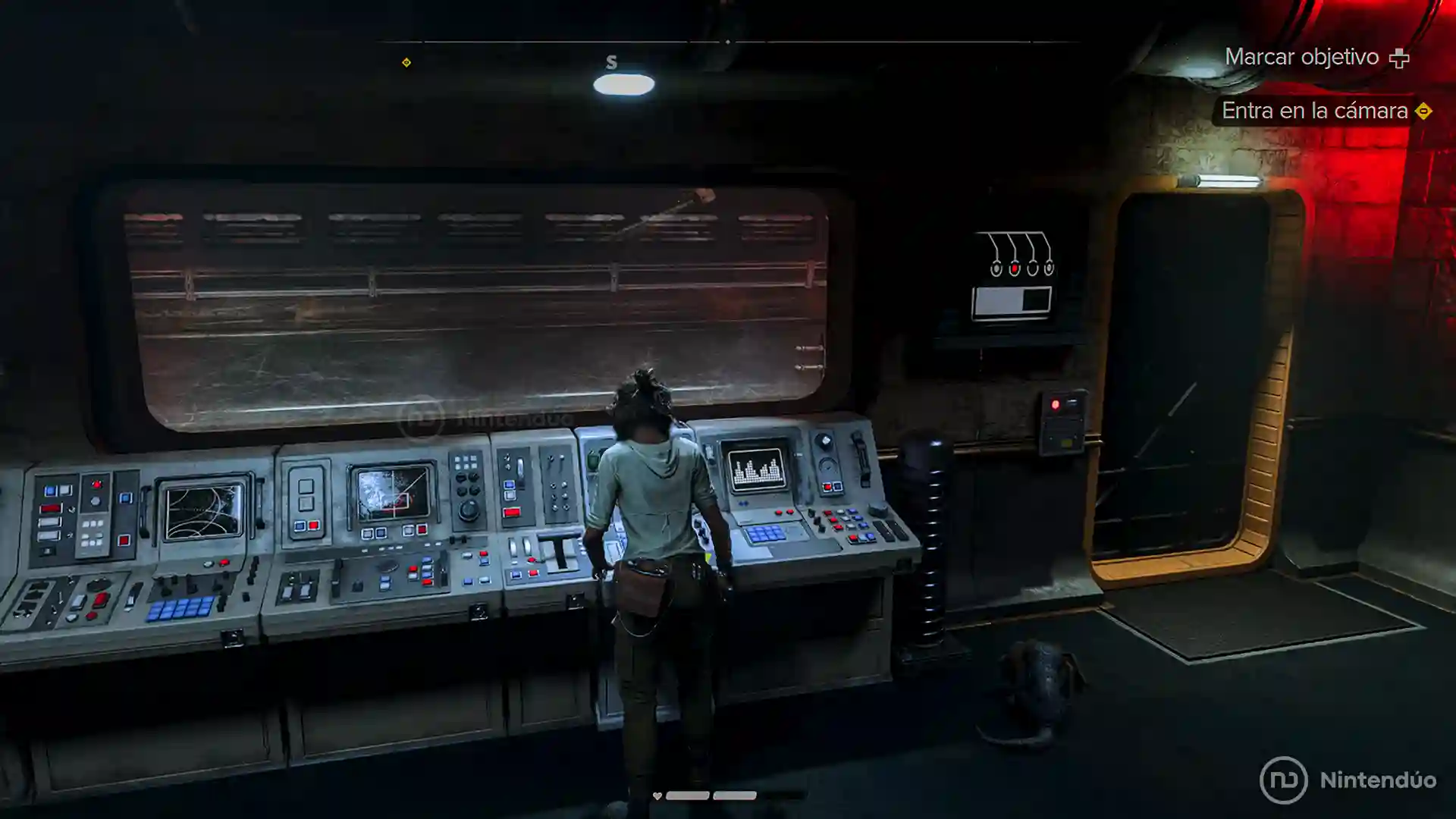 Kay Vess controla un panel de instrumentos en una nave espacial en Star Wars Outlaws, mirando a través de una ventana panorámica.