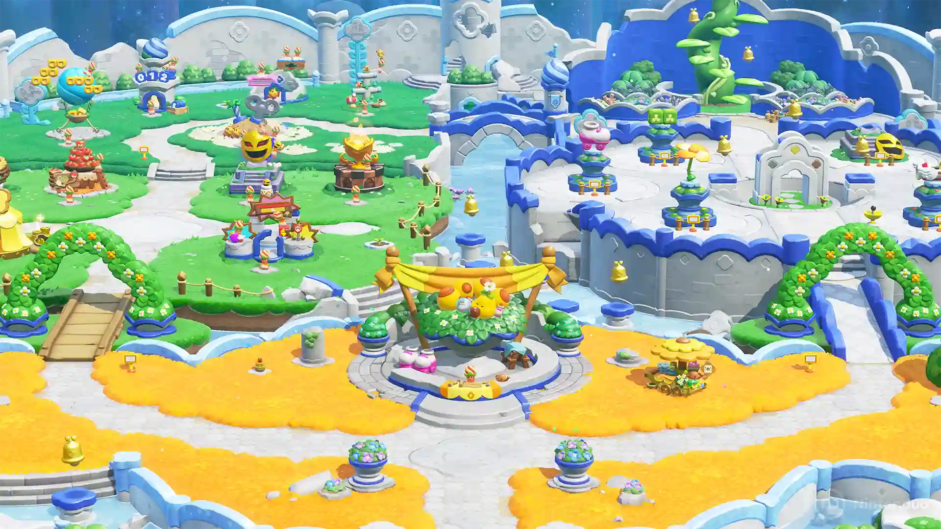 Super Mario Bros. Wonder – Nintendo Switch 2 Edition: vista aérea de un parque colorido con plazas, caminos, fuentes y decoraciones sobre islas flotantes azules y amarillas.