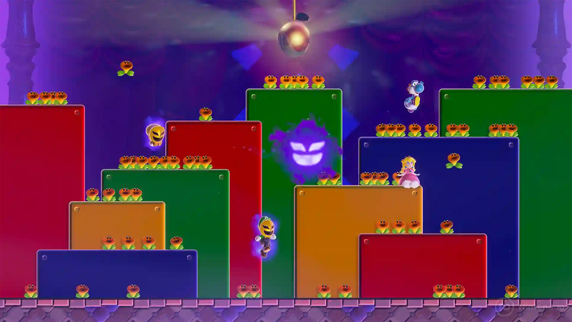 Super Mario Bros. Wonder – Nintendo Switch 2 Edition: nivel con plataformas escalonadas de colores rojo, verde, azul y naranja con numerosos enemigos y máscaras en un escenario nocturno iluminado.