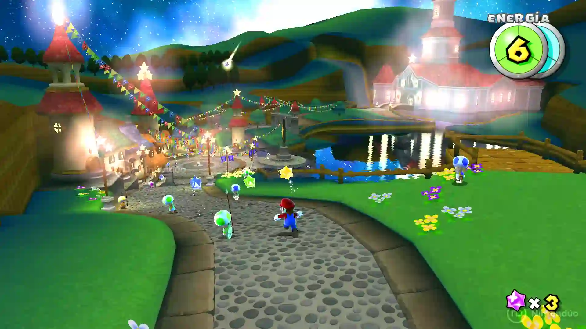 Mario de Super Mario Galaxy caminando por un pueblo festivo lleno de Toads verdes, banderines de colores y farolillos luminosos.