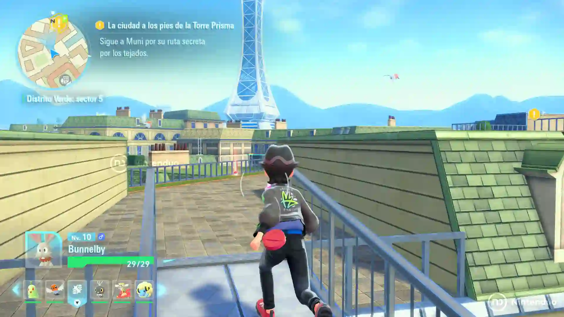 El protagonista de Leyendas Pokémon Z-A para Nintendo Switch 2 corre por los tejados de Ciudad Luminalia siguiendo la ruta de Muni con la Torre Prisma de fondo y su Bunnelby en el equipo.
