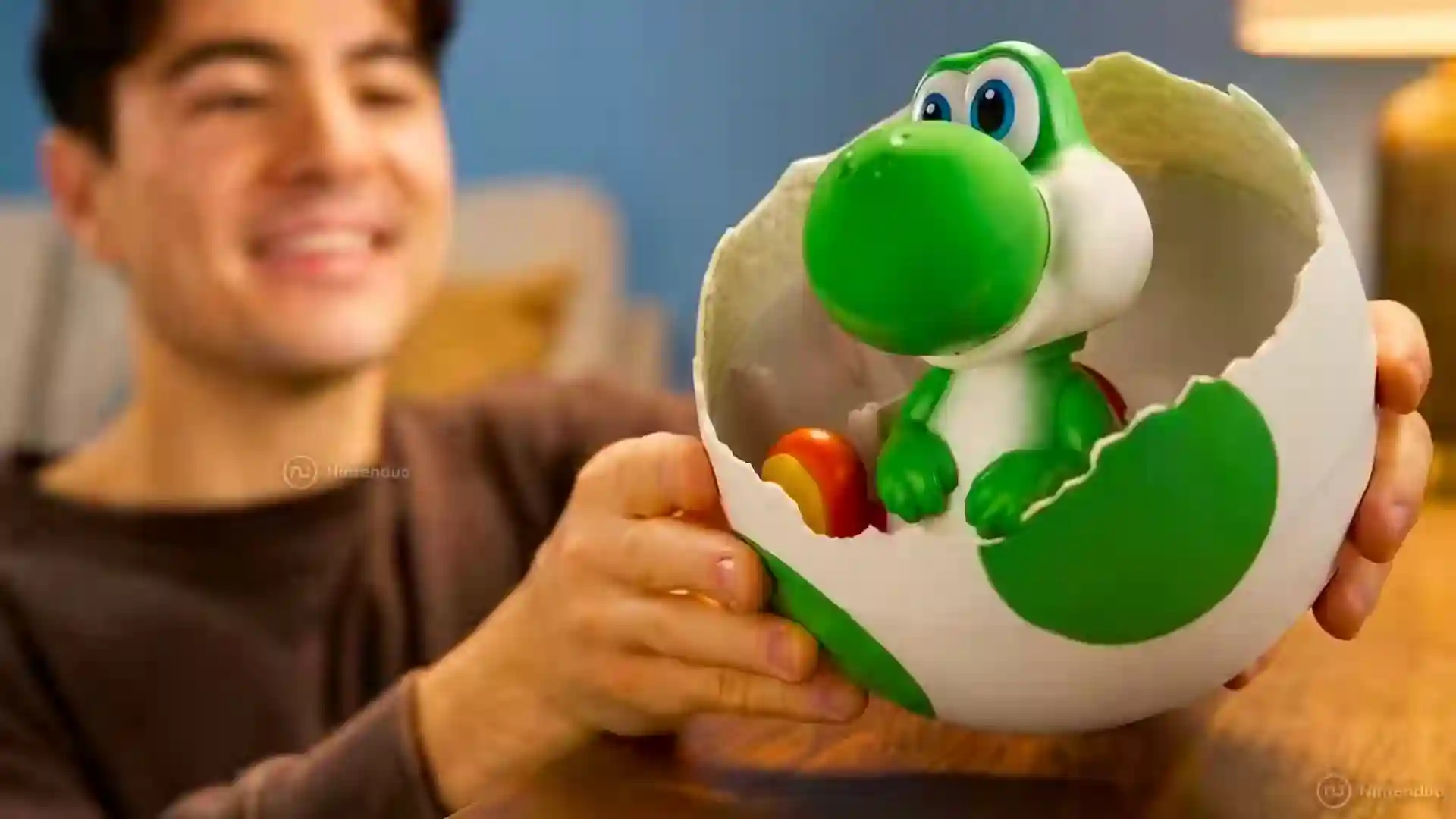 Persona sosteniendo el juguete oficial de Yoshi saliendo de un huevo de Super Mario, de la película de Super Mario Bros.