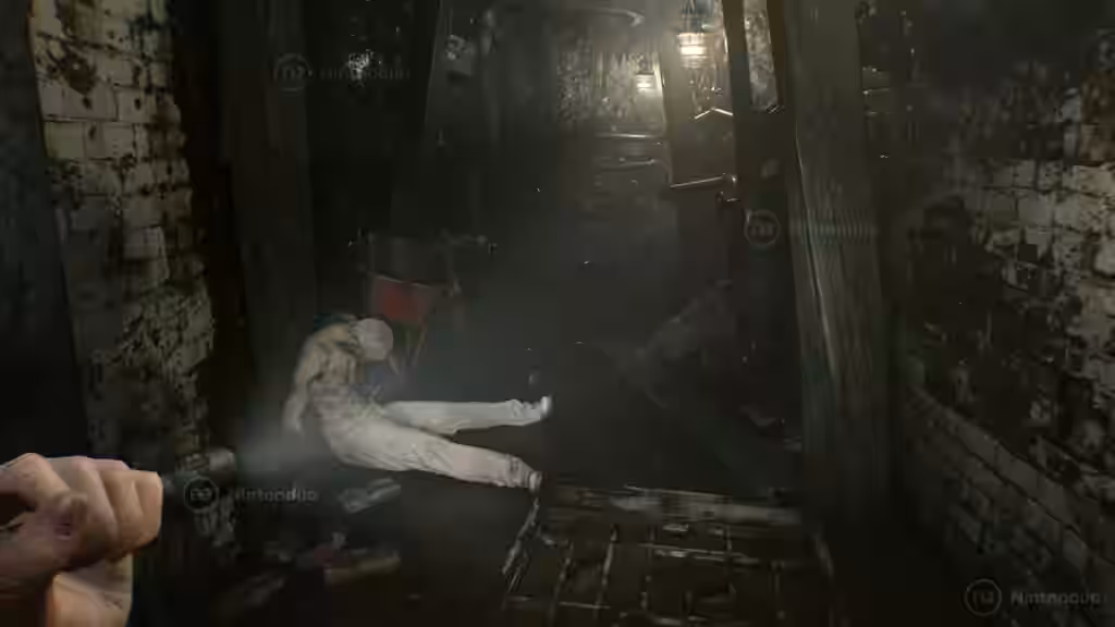 Una linterna ilumina un pasillo oscuro y un cuerpo pálido apoyado en la pared dentro de un túnel estrecho en Resident Evil Requiem para Nintendo Switch 2.