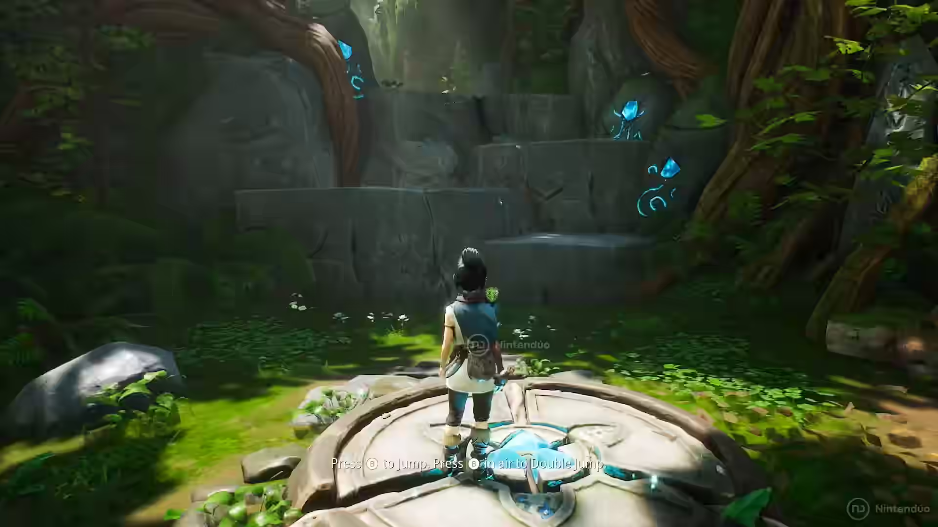 Kena se queda sobre una plataforma de piedra con símbolos azules ante una cascada rodeada de flora espiritual en Kena: Bridge of Spirits.